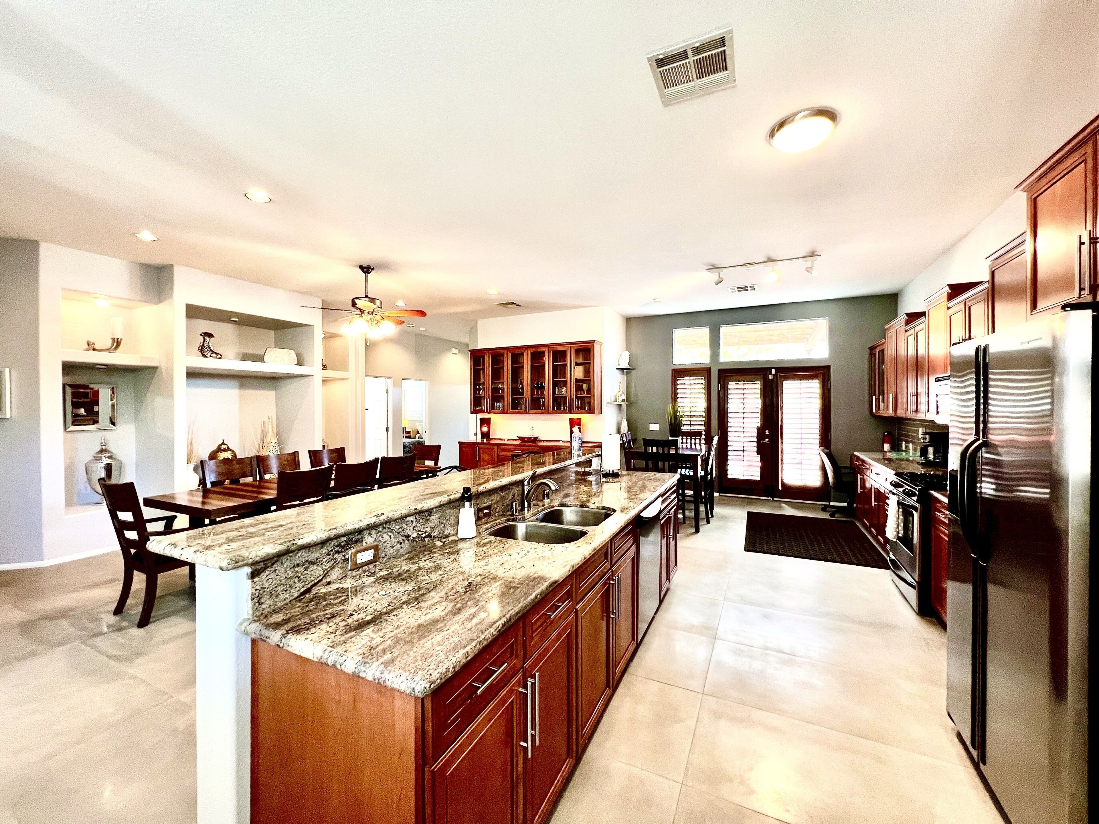 A spacious kitchen with granite countertops, stainless steel appliances, and wooden cabinets.