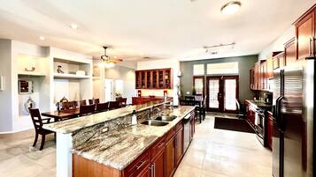 A spacious kitchen with granite countertops, stainless steel appliances, and wooden cabinets.