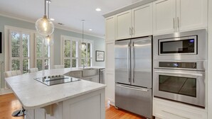 A modern kitchen with a central island, stainless steel appliances, and pendant lighting. - Wright Square Loft: Amazing Unit A in Downtown Savannah With Great Views! (Savannah)