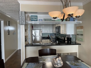 Enjoy cooking in this well-equipped kitchen with a refrigerator, countertop, and hanging light fixture.