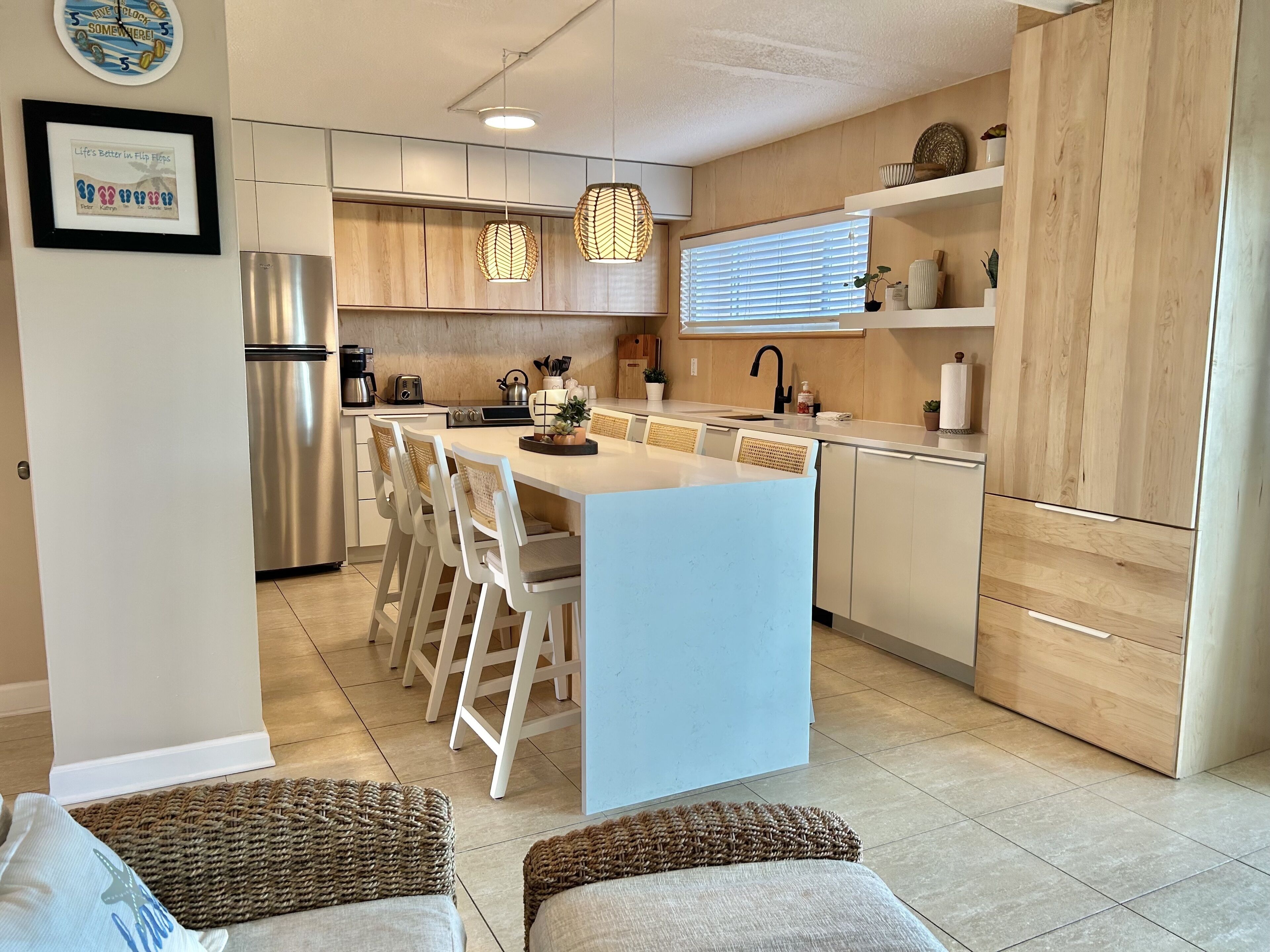 A modern kitchen with a central island, stainless steel appliances, and wooden cabinetry.
