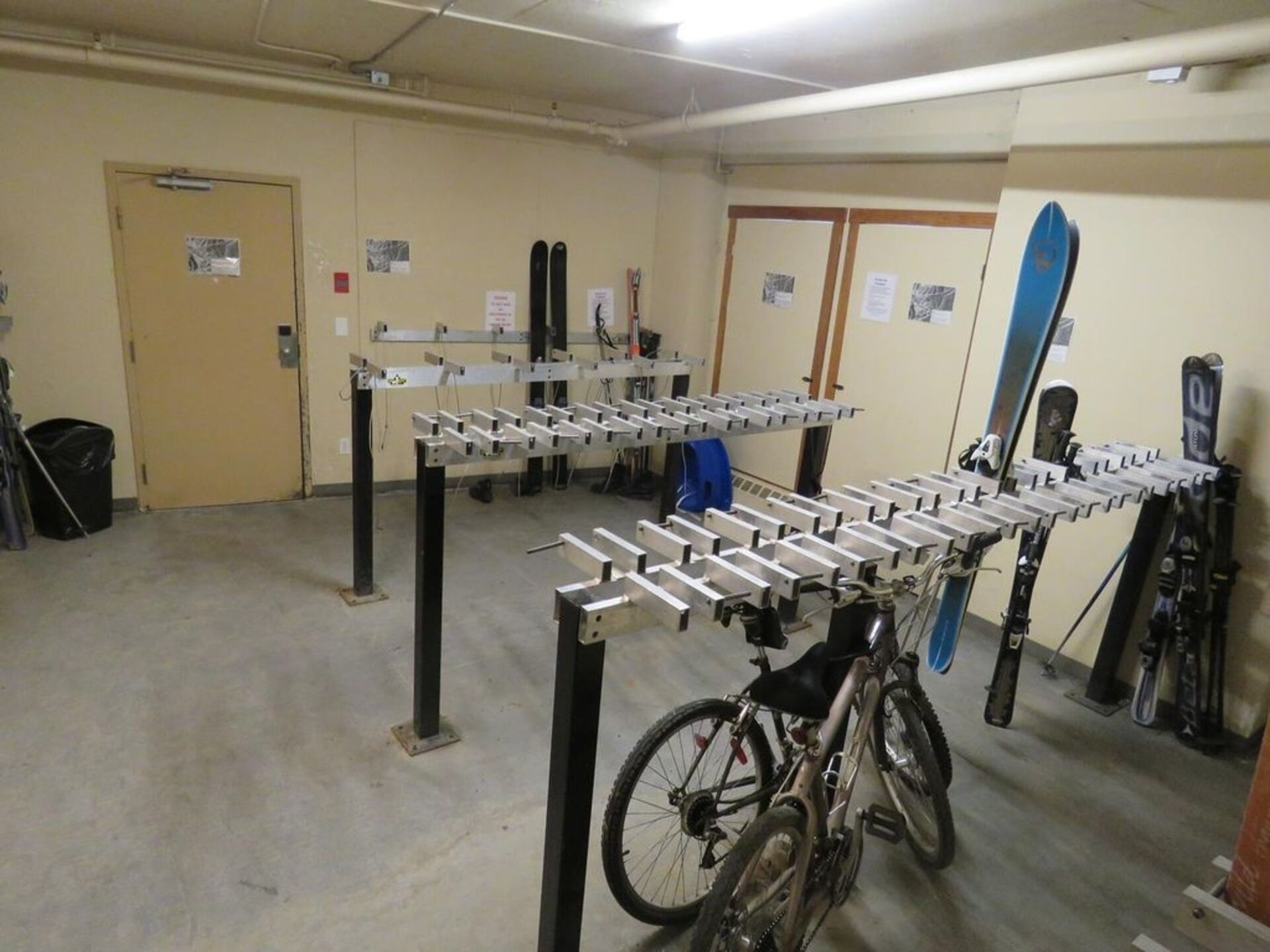 A ski rental facility with multiple ski racks and a bicycle in the foreground.