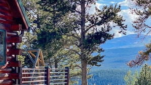 A log cabin with a wooden deck overlooking a forested valley and distant mountains. - Log Home, Hot Tub & Pool-Table Game Room - 25 mi to Breckenridge (Fairplay)