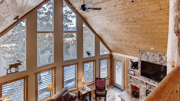 A spacious loft with large windows, a fireplace, and a ceiling fan. - Log Home, Hot Tub & Pool-Table Game Room - 25 mi to Breckenridge (Fairplay)