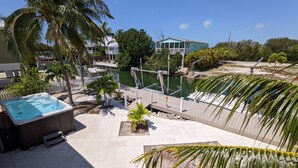 Un jacuzzi, un muelle y vistas de un puerto deportivo con barcos.