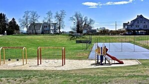 Un parque infantil con columpios, tobogán y estructura para escalar.