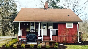 A red wooden house with a porch, a barbecue grill, and a small deck with chairs. - Peaceful Cottage Retreat Near Nashville! (Ashland City)