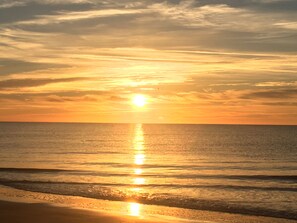 A sunset over a calm sea with a clear horizon.