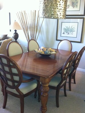 Enjoy meals in this dining area with a wooden table and comfortable chairs, surrounded by artwork.