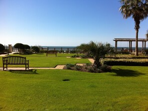 Relax in a serene outdoor space with a lawn, bench, and pergola, perfect for unwinding and taking in the sea views.