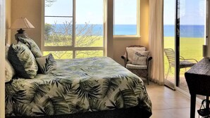 A bedroom with a bed, a chair, and a view of the outdoors. - 180 degree Ocean Front Unobstructed View. Sleeps 8
New appliances. (Princeville)