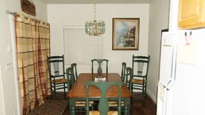 A dining room with a wooden table and six chairs, a chandelier, a painting on the wall, and a refrigerator. - 4 Br 3.5 baths Towne Home Driggs Idaho. Close to skiing, Jackson Hole, GTNP, YNP (Driggs)