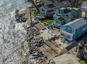 A waterfront cottage with a patio, a view of the water, and a stone wall. - Waterfront Cottage on Lake Erie (Huron)