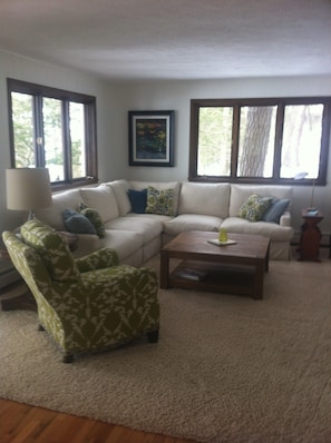 Relax in this inviting living space with a large sofa, armchair, and coffee table.