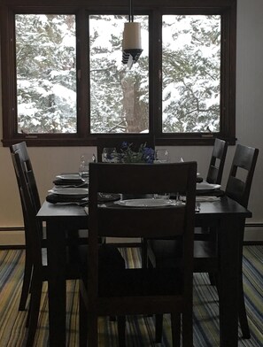 Enjoy meals with a view of snow-covered trees from this dining area with a table for four.