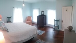 Une chambre à coucher avec un lit, une commode, une chaise et un bureau.