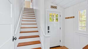 A white interior with a wooden staircase, a door labeled "NAPA," and a window with blinds. - Private Hot Tub/Short Walk to Downtown (Napa)