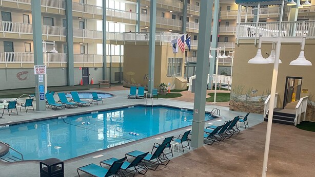 Una piscina interior con sillas de descanso y una bandera.