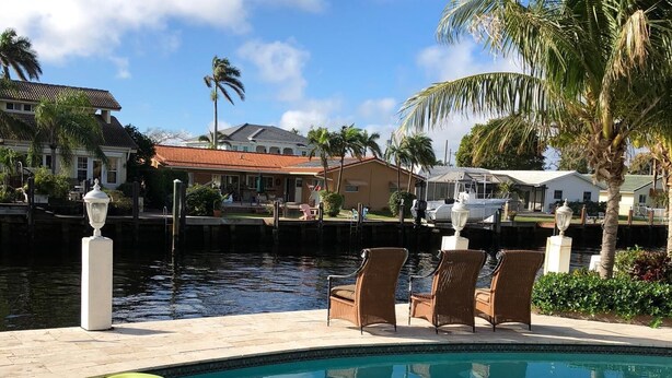 A swimming pool with clear water, surrounded by lounge chairs and a small inflatable float.