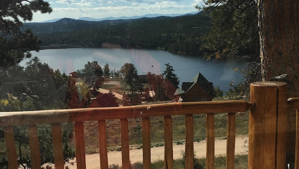 Un pontile di legno con vista su un lago e una foresta.