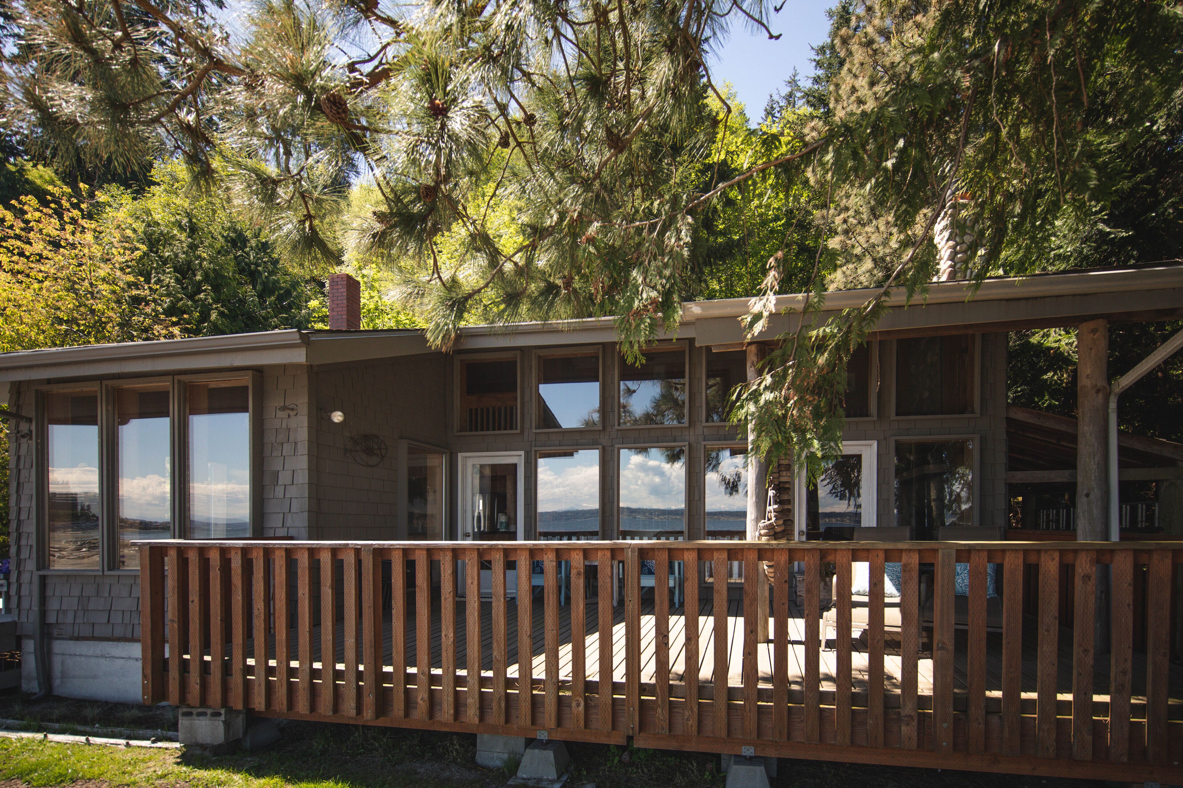 East side of house, wall of windows and deck overlooking the ocean