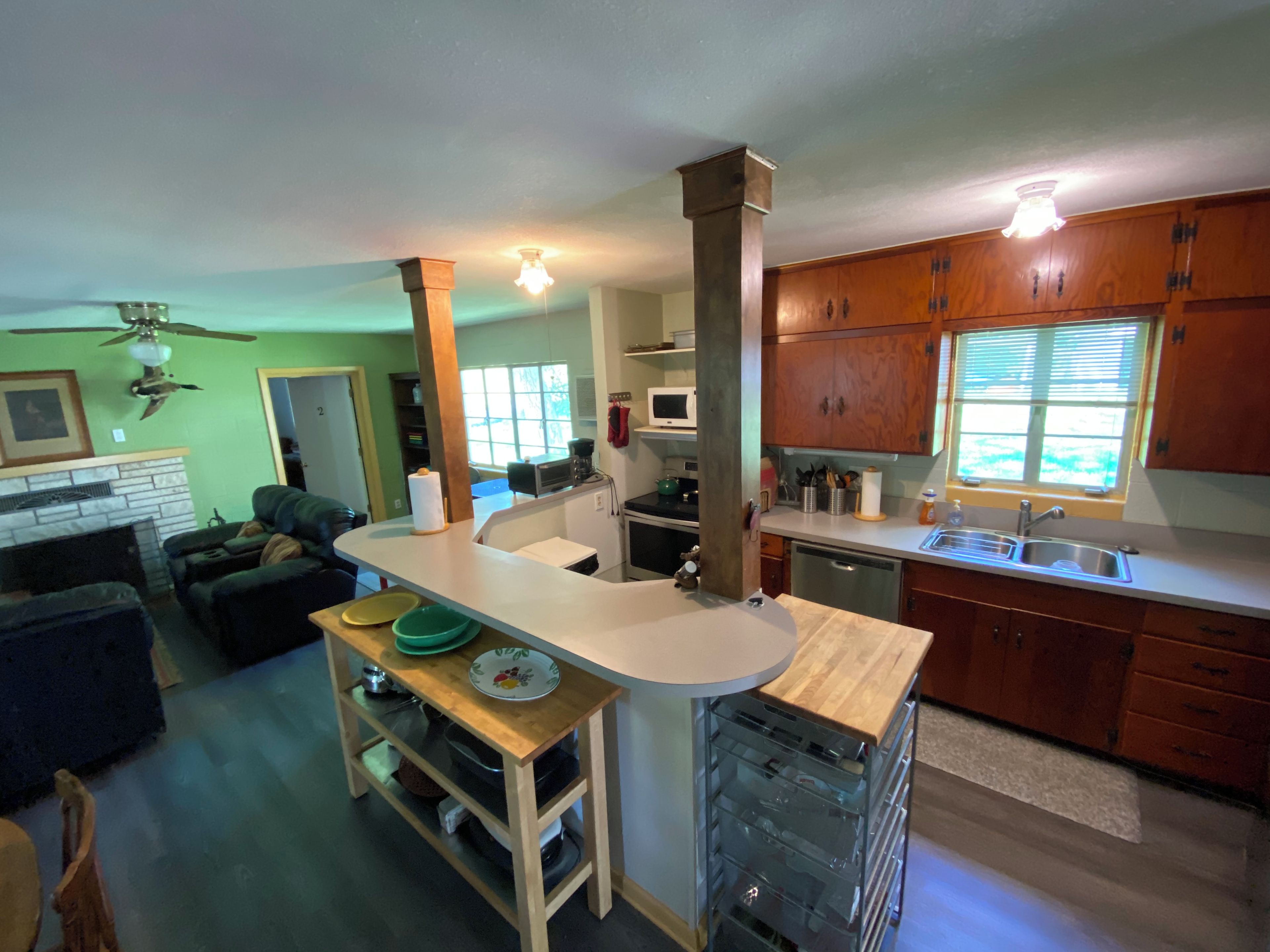 A kitchen with wooden cabinets, a central island, and a dining area with a table and chairs.