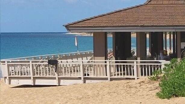 A beachside building with a sloped roof, a white railing, and a view of the ocean. - WOW- New 2bd/2ba, Largest Lanai w/Ocean & Golf Course Views, Lowest Resort Fee! (Lahaina)