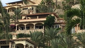 Un immeuble à plusieurs étages, doté de balcons en arc de cercle, de murs en pierre et d’une végétation luxuriante.