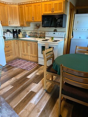Una cucina con mobili in legno, un fornello, un forno a microonde e un lavandino.