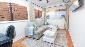 Una sala de estar moderna con sofá, mesa de centro y ventilador de techo.