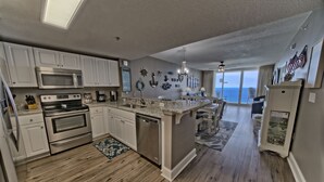 A spacious kitchen with white cabinets, stainless steel appliances, and a large island.