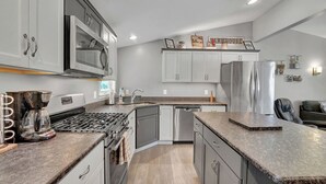 A modern kitchen with white cabinets, stainless steel appliances, and granite countertops. - Beautiful and modern 3 bedroom, 1 bath Duplex.  Sleeps 6 (Chaffee)
