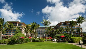 Un hôtel à étages, bordé de palmiers, avec un ciel bleu et dégagé.