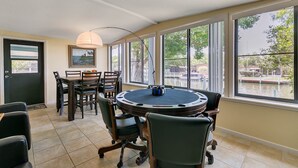 A dining area with a round table, chairs, and a lamp.