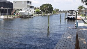 A marina with docked boats, a wooden pier, and residential buildings in the background.