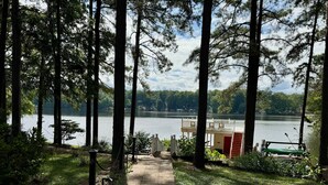 A pathway leading to a lakeside deck with a view of the lake and surrounding trees.