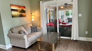 A living room with a sofa, a coffee table, and a painting on the wall.