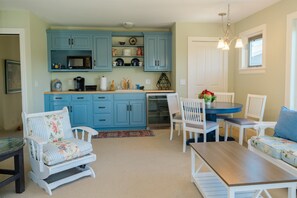 A kitchen with blue cabinets, a dining table with chairs, and a small rug. - Rent Two Suites On A Beautiful Five Acre Estate (Leland)