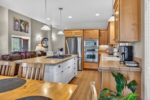 A modern kitchen with wooden cabinets, stainless steel appliances, and a central island.