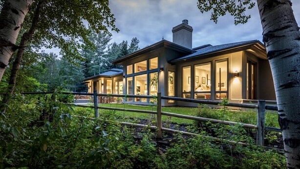 A modern house with large glass windows, a well-maintained garden, and a wooden fence. - Renovated, refined, immaculate single-story mountain home 2 miles south of Baldy (Hailey)