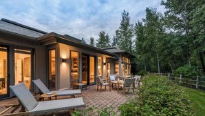 A modern house with a patio area featuring outdoor furniture and a well-maintained garden. - Renovated, refined, immaculate single-story mountain home 2 miles south of Baldy (Hailey)