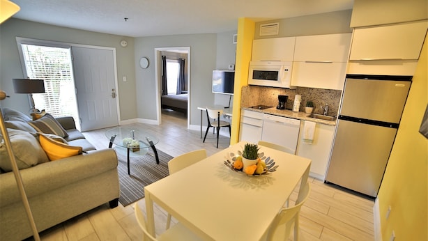 A modern apartment with a living room, dining area, and kitchen.