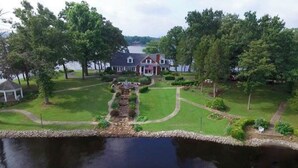 A large house with a well-maintained lawn and a pond in the foreground.