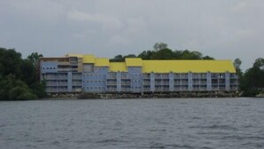 A multi-story hotel with a yellow roof, located near a body of water. - Middle Bass Island-Premium Lakefront Condo with Large Lakefront Covered Patio  (Middle Bass Island)