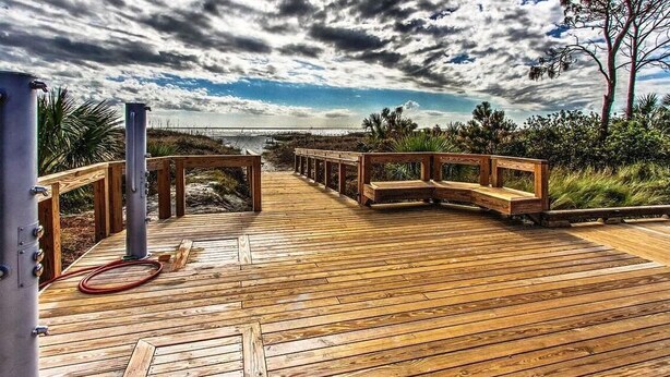 Eine Holzterrasse mit Blick auf den Ozean und einem bewölkten Himmel.