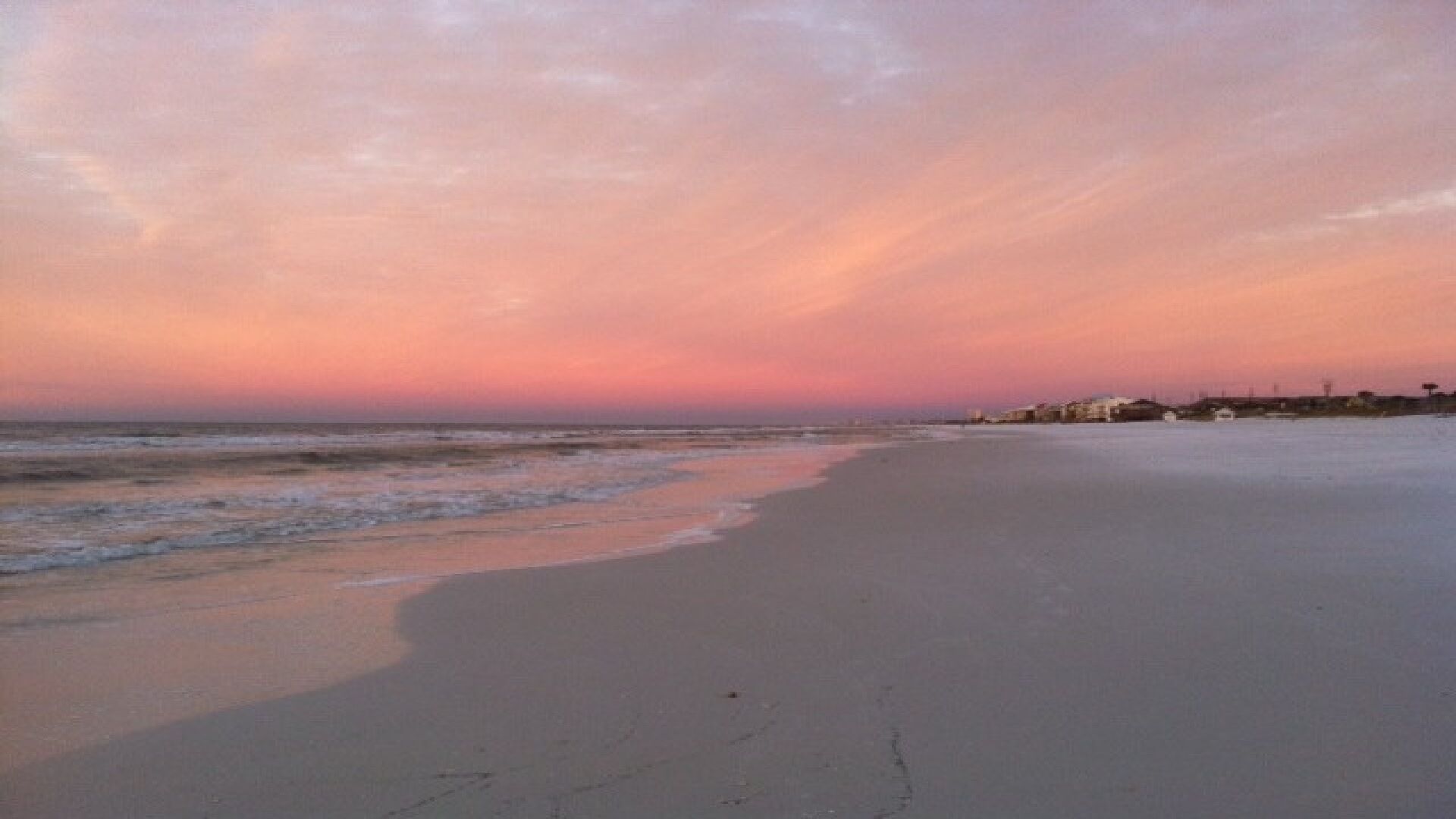 Una playa con un mar tranquilo y un cielo al atardecer.