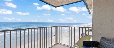 Un balcon avec vue sur la plage et l’océan.