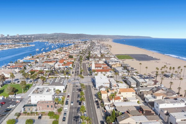 Zona residencial costera con playa, casas y una carretera.
