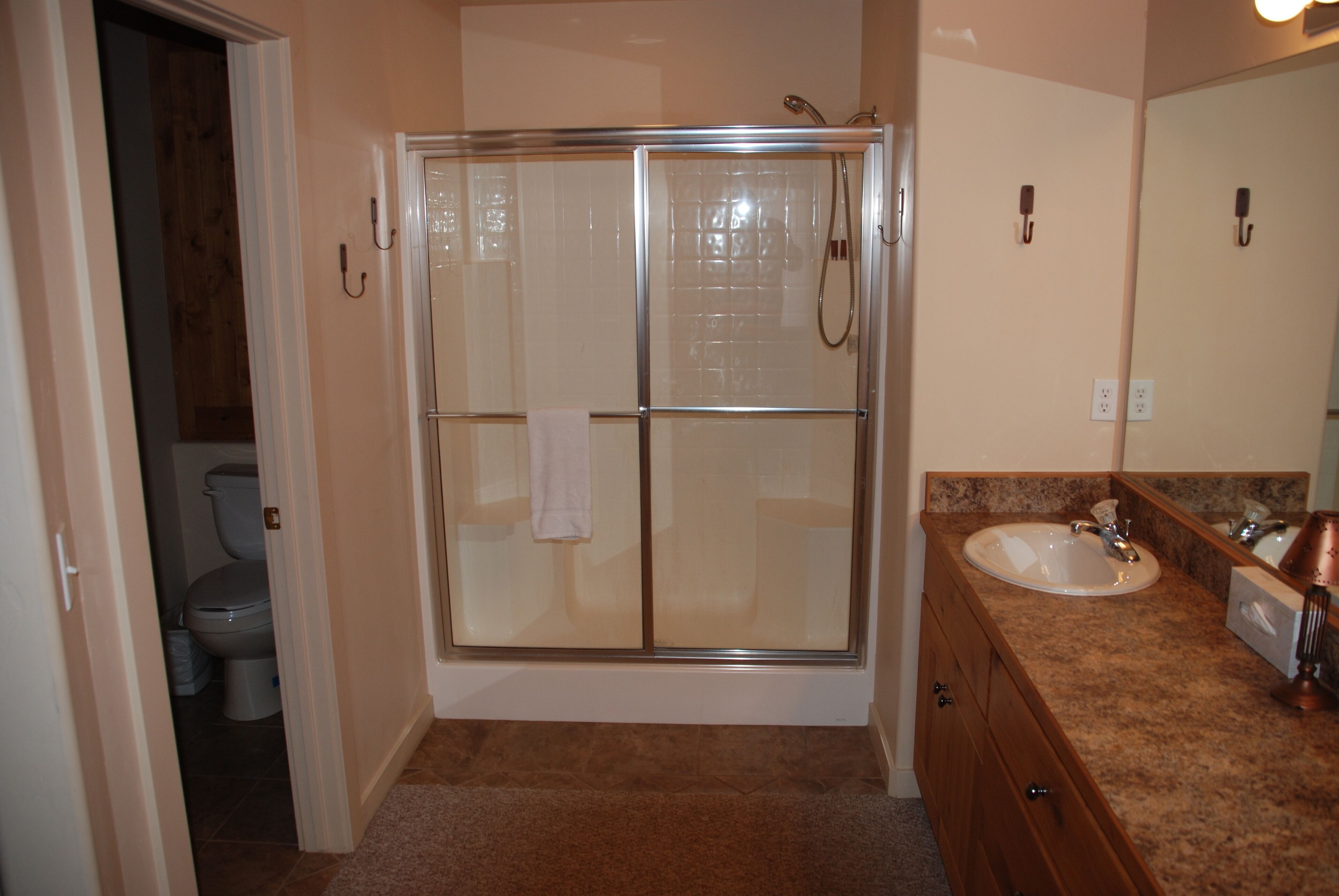 Une salle de bain avec une douche à parois de verre, un lavabo et des toilettes.
