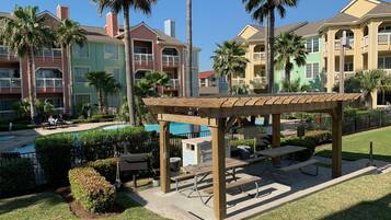 A resort with a pool area, outdoor seating, and palm trees.